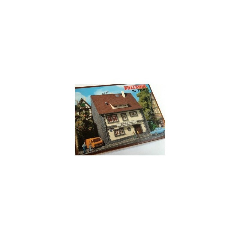 Model redukcyjny warsztatu instalacyjnego, skala 1/160N, VOLLMER. Detaliczny budynek z czerwonym dachem i dwoma postaciami.