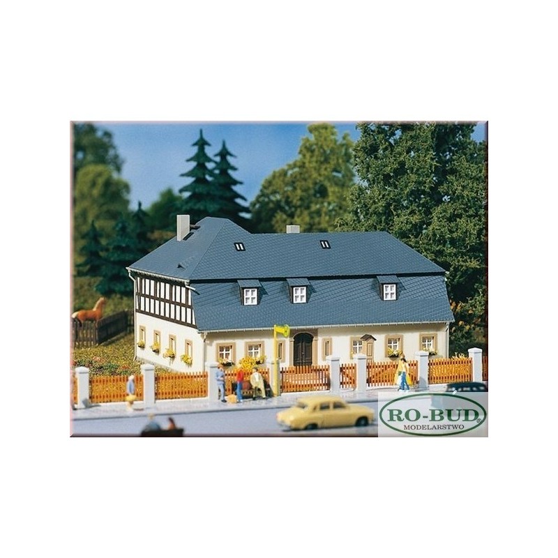 Dom przy Mill Road 1, skala 1:87, RO-BUD. Biały budynek z szarym dachem, drewniane elementy, ogrodzenie.