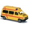 Model redukcyjny VW T4, skala 1:87, AWM. Żółty ambulans z czerwonym krzyżem i napisami DRK.