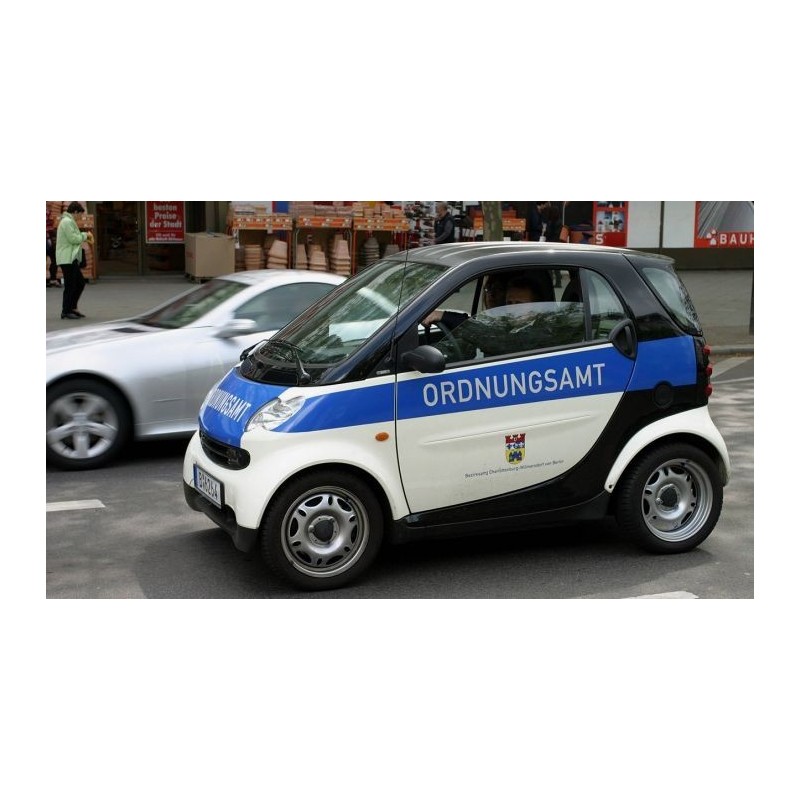 Model redukcyjny Smart Fortwo Ordnungsamt, skala 1:87, metal i plastik. Biały, niebieski i czarny, oznaczenia służb miejskich.