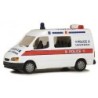 Model redukcyjny FORD Transit Police, skala 1:87. Biały samochód z czerwonym paskiem i napisem POLICE w języku angielskim i chiń