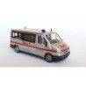 Ford Transit Johanitter, skala 1:87, Rietze. Biały samochód ratunkowy z czerwonymi pasami i napisem Johanniter.