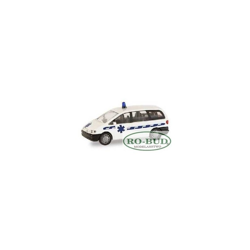 Model redukcyjny FORD Galaxy Ambulance, skala 1:87. Biały samochód z niebieskimi paskami i sygnałem.
